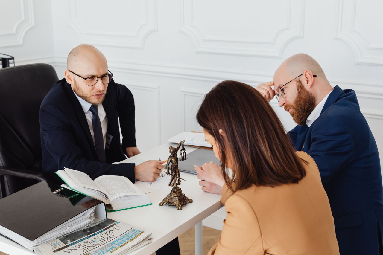 The Art of Drawing Readers In: Your attractive post title goes here Lawyer consulting clients in a modern office setting, serious discussion.